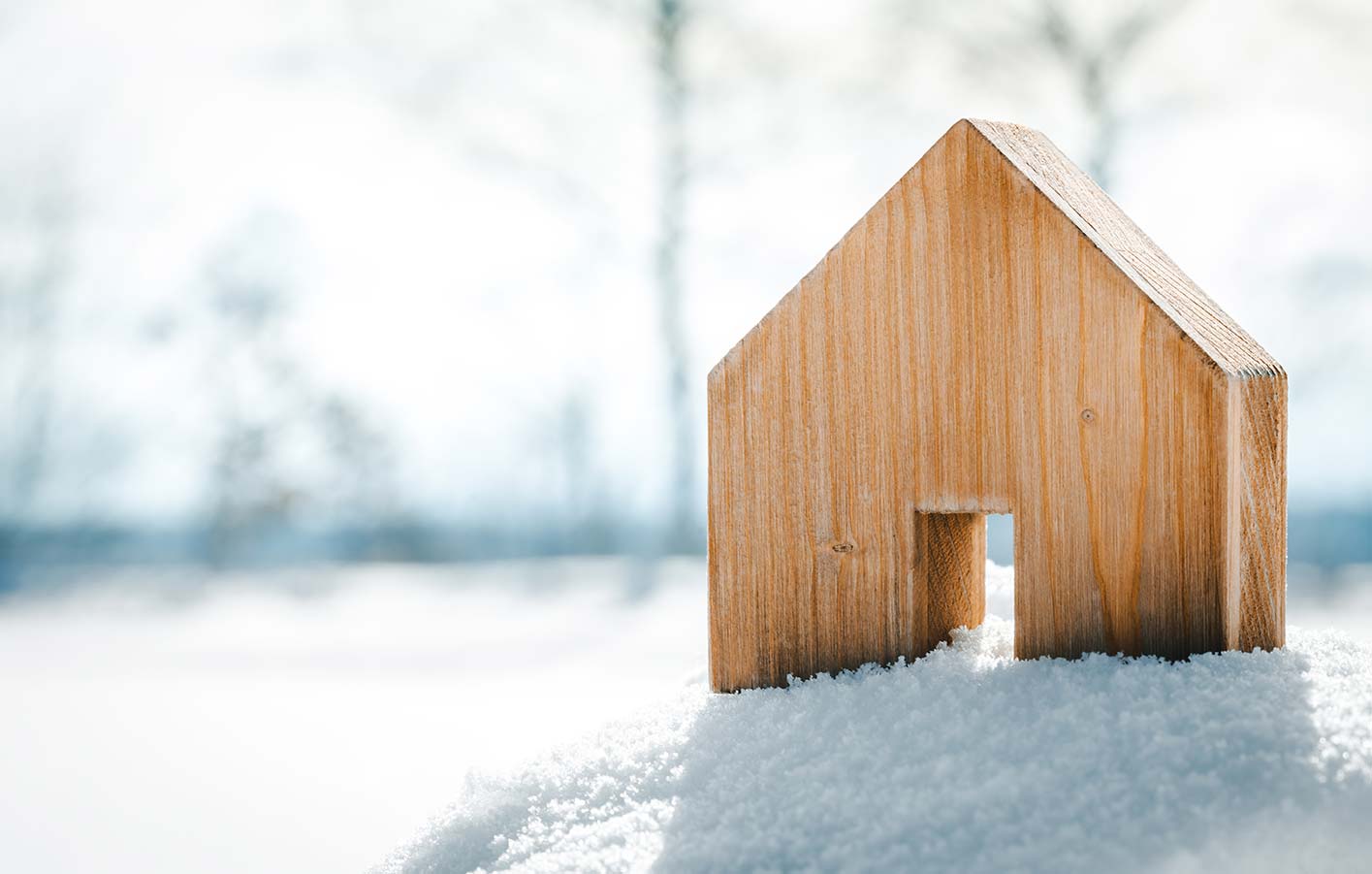 Modell eines Holzhauses im Schnee